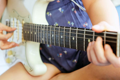 Midsection of man playing guitar