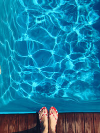 Low section of woman standing at poolside