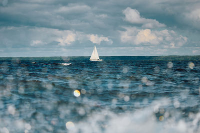 Sailboat sailing on sea against sky