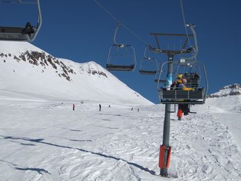 Person sitting on ski lift during winter