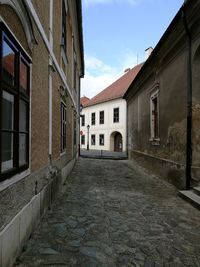 Narrow street amidst buildings against sky