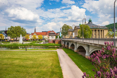 View of arch bridge and buildings against cloudy sky