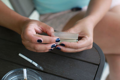 Cropped hands of woman holding tobacco product