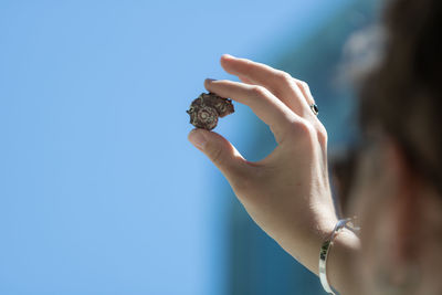 Close-up of woman hand holding blue sky