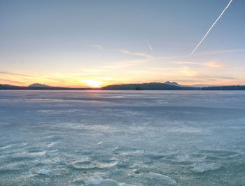 Summer resort under ice within long winter. breathtaking freeze sunset over frozen lake