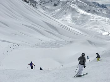 People skiing on snowcapped mountain in lech
