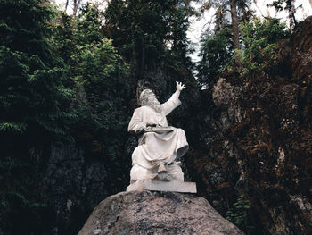 Low angle view of statue against rock