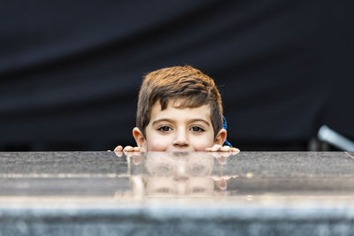 Portrait of boy behind railing