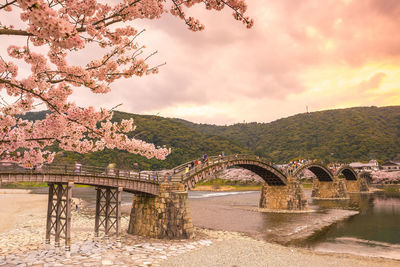 Arch bridge over river against sky