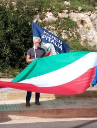 Rear view of man holding flag