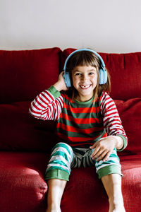 Portrait of smiling girl sitting on sofa