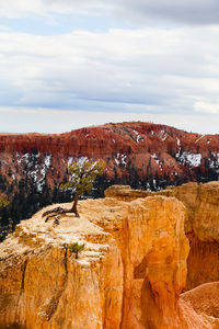 Rock formations against cloudy sky