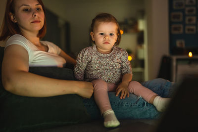 Portrait of cute boy sitting on sofa at home