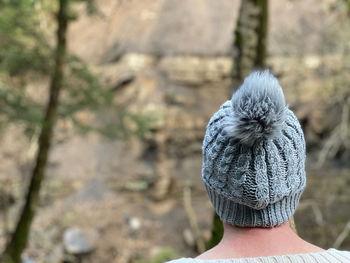 Rear view of woman wearing a knit hat walking in woodlands