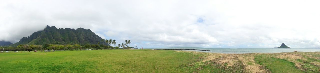 sea, sky, tranquil scene, water, scenics, tranquility, beauty in nature, horizon over water, nature, cloud - sky, grass, landscape, mountain, cloudy, idyllic, non-urban scene, cloud, day, weather, built structure