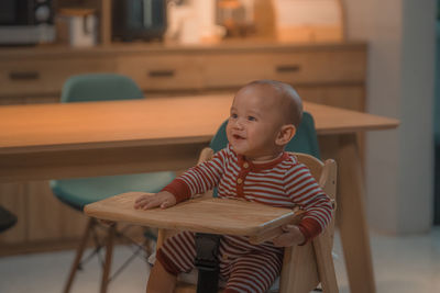 Portrait of cute boy sitting on chair