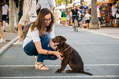 Full length of woman with dog in city