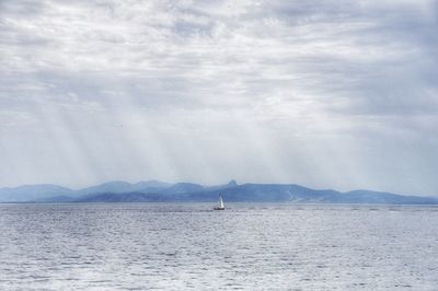 Sailboat sailing on sea against sky