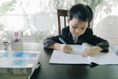 Full length of a boy holding paper