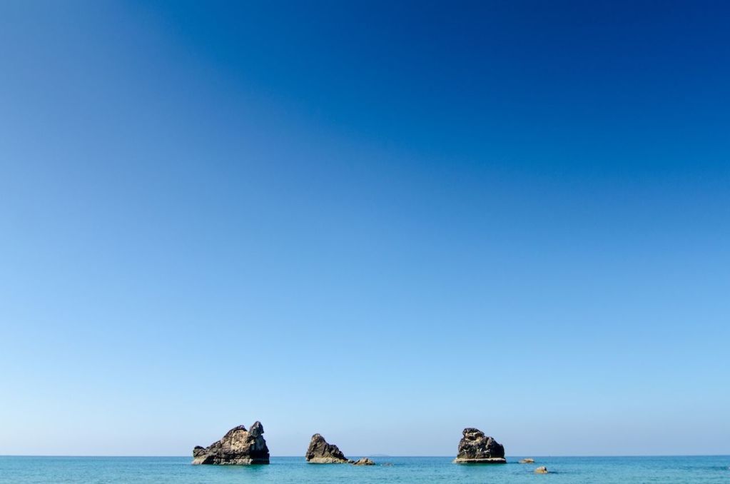 sea, water, horizon over water, clear sky, waterfront, copy space, blue, tranquil scene, nautical vessel, scenics, tranquility, beauty in nature, transportation, boat, nature, mode of transport, idyllic, seascape, ocean, rock formation