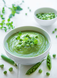 Fresh green pea soup bowl on gray concrete background