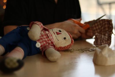 Close-up of hand holding toy on table at home