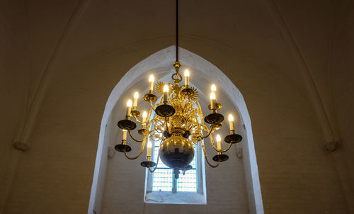 Low angle view of illuminated lamps hanging in temple