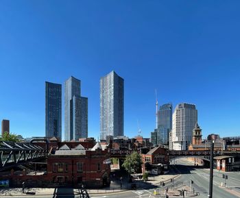 Modern buildings in city against clear blue sky