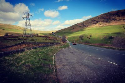 Scenic view of road by mountain against sky