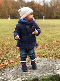 Girl sucking pacifier while standing on rock