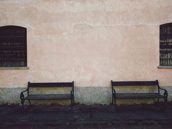 Empty bench against building