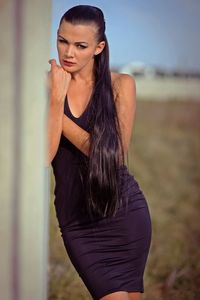 Beautiful young woman wearing hat standing on land