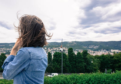 Woman standing on field against sky