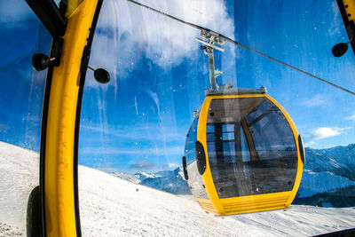 Close-up of yellow wheel against blue sky