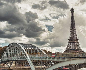 Low angle view of bridge against cloudy sky