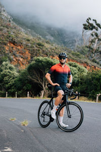 Rear view of man riding bicycle on road