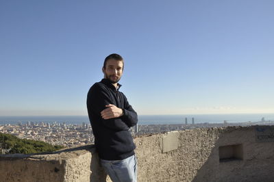 Portrait of young man standing against sky