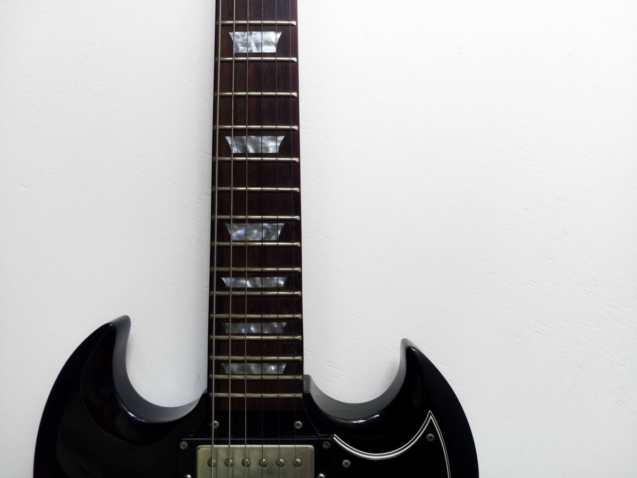 CLOSE-UP OF GUITAR ON BUILDING