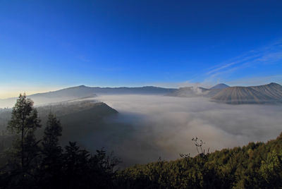 Scenic view of mountains against blue sky