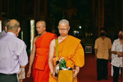 Rear view of people standing in temple