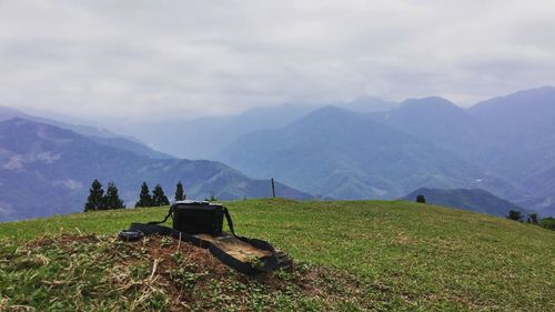 Scenic view of grassy field against cloudy sky