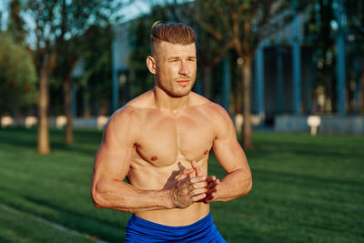 Full length of shirtless man standing outdoors