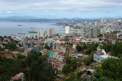 High angle view of city by sea against sky