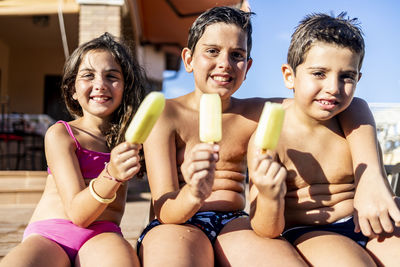 Three funny kids eating an ice lolly