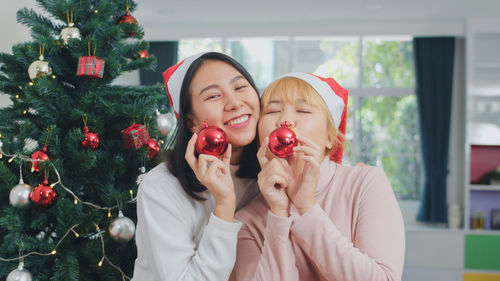 Midsection of woman with christmas tree at home