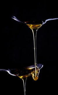 Close-up of wineglass on glass against black background