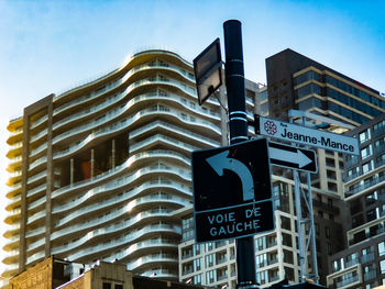 Low angle view of road signs against buildings in city