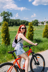 Young woman riding bicycle on field