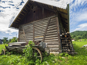 Old wagon by barn on field