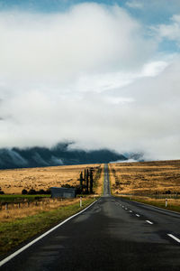 Empty road along landscape against sky